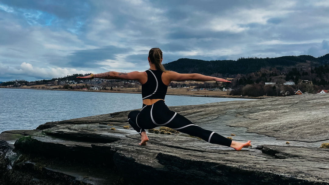 Sprek jente gjør yoga på svaberget iført klær fra Moonchild